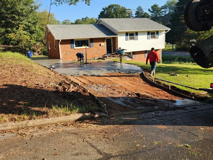 Crew pouring and finishing a concrete driveway